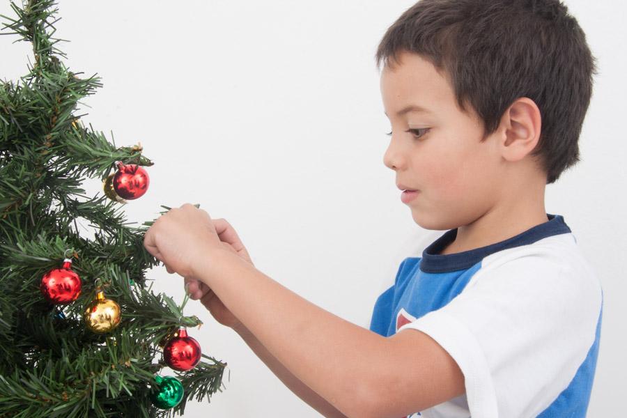 Niño armando un arbol de Navidad