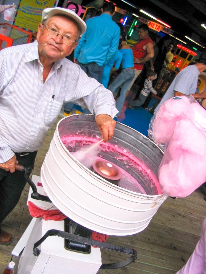 Adulto mayor haciendo algodón dulce en una calle ...