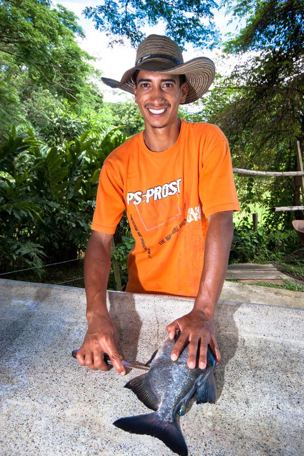 Hombre preparando un pescado para su cocción 