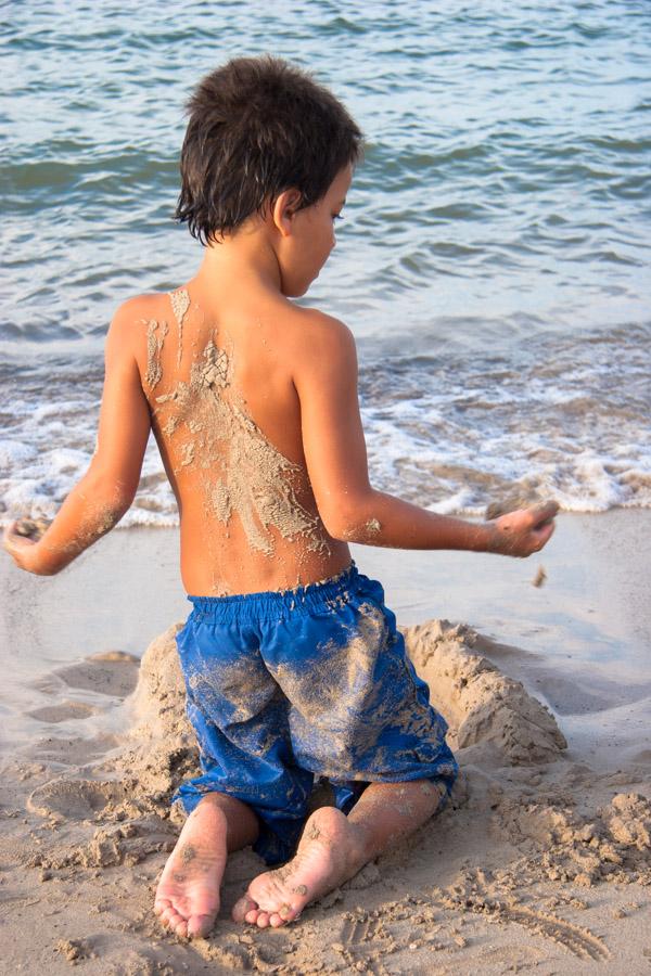 Niño Jugando en la playa de espaldas