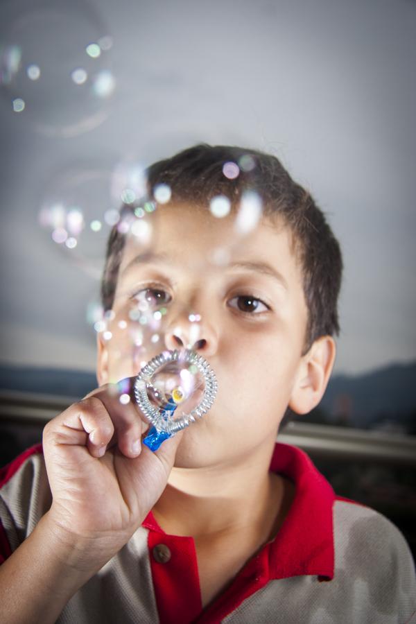 Niño soplando burbujas de jabon