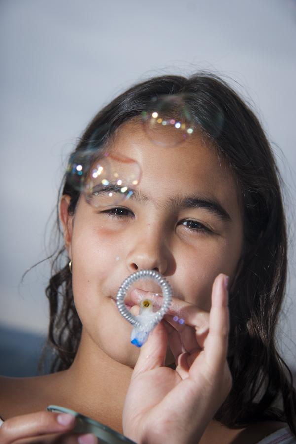 Niña soplando burbujas de jabon