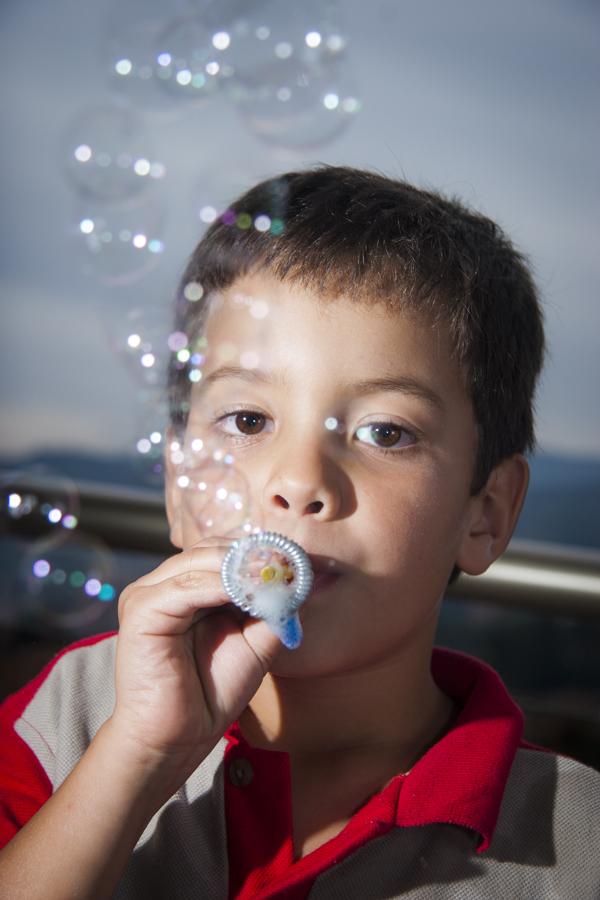 Niño soplando burbujas de jabon