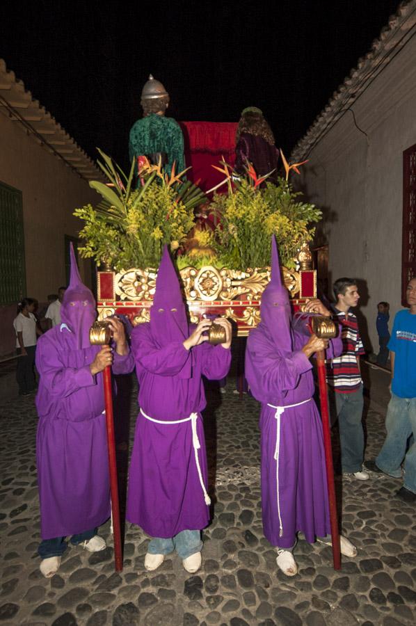 Personas con casulla llevando una imagen religiosa...