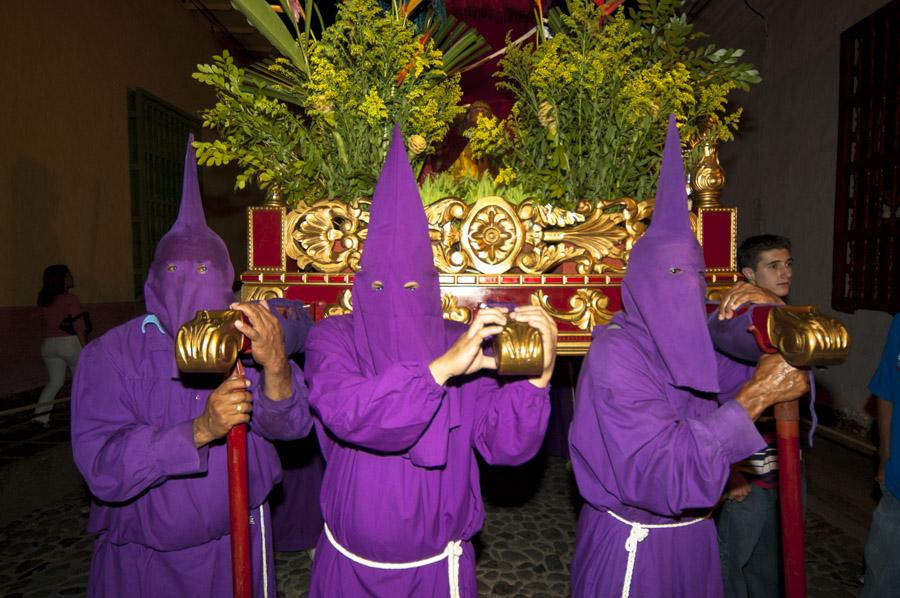 Personas con casulla llevando una imagen religiosa...