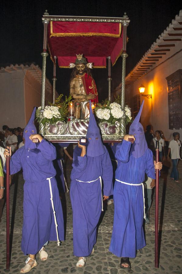 Personas con casulla llevando una imagen religiosa...