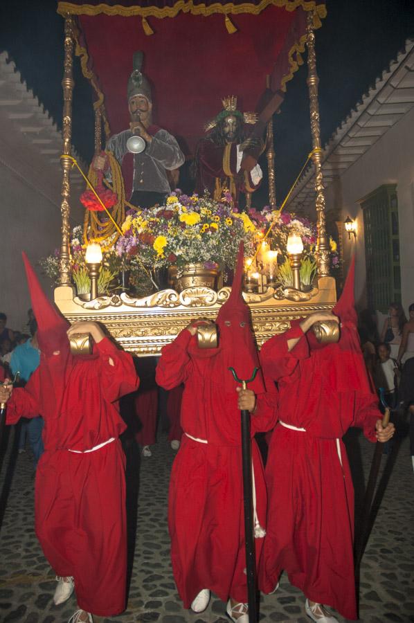 Personas con casulla llevando una imagen religiosa...