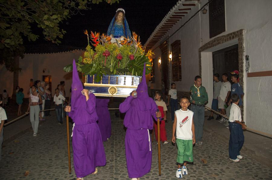 Personas con casulla llevando una imagen religiosa...