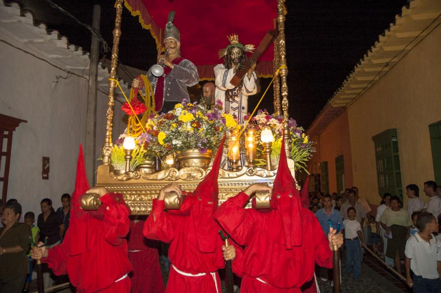 Personas con casulla llevando una imagen religiosa...