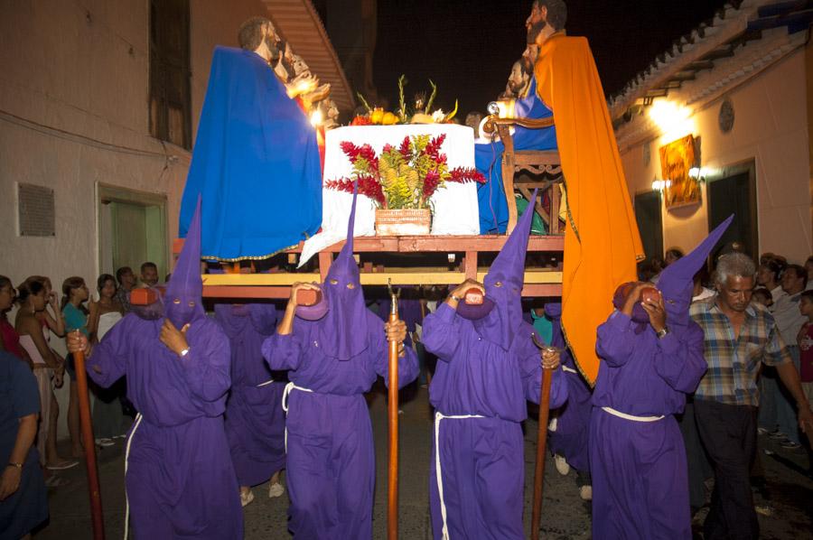 Personas con casulla llevando una imagen religiosa...