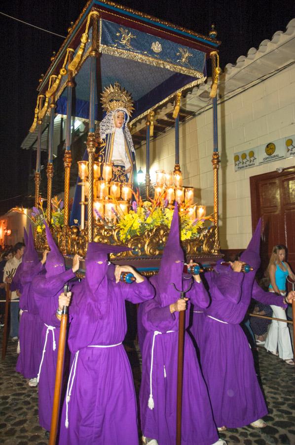 Personas con casulla llevando una imagen religiosa...