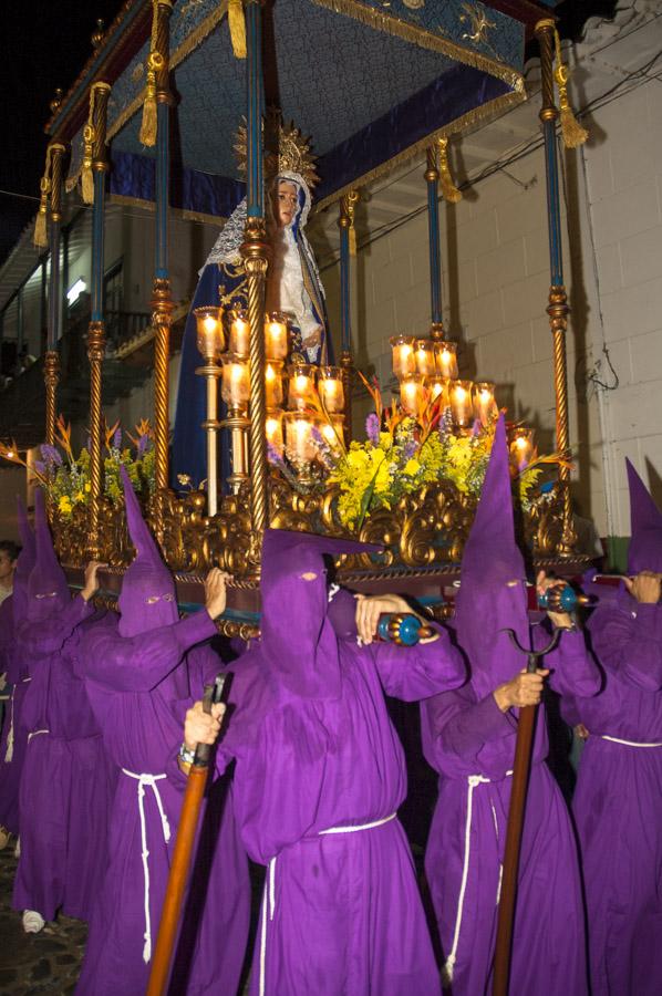 Personas con casulla llevando una imagen religiosa...