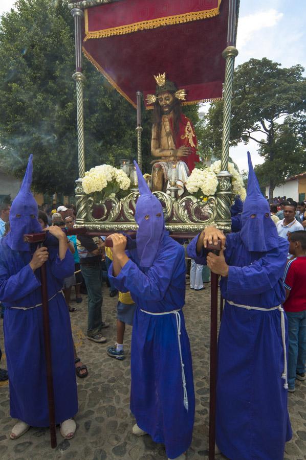 Personas con casulla llevando una imagen religiosa...