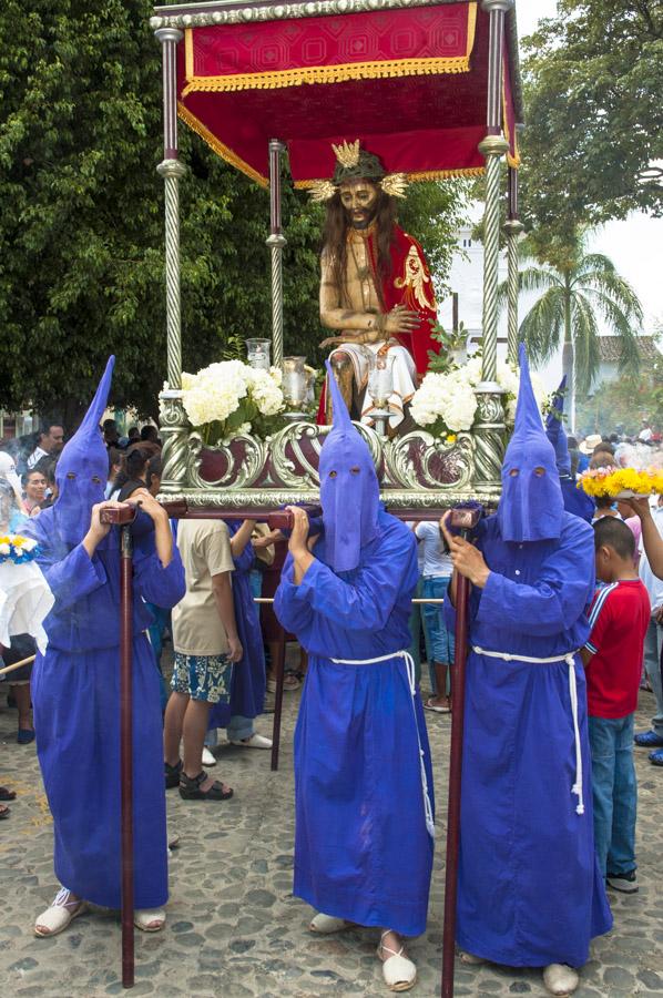 Personas con casulla llevando una imagen religiosa...