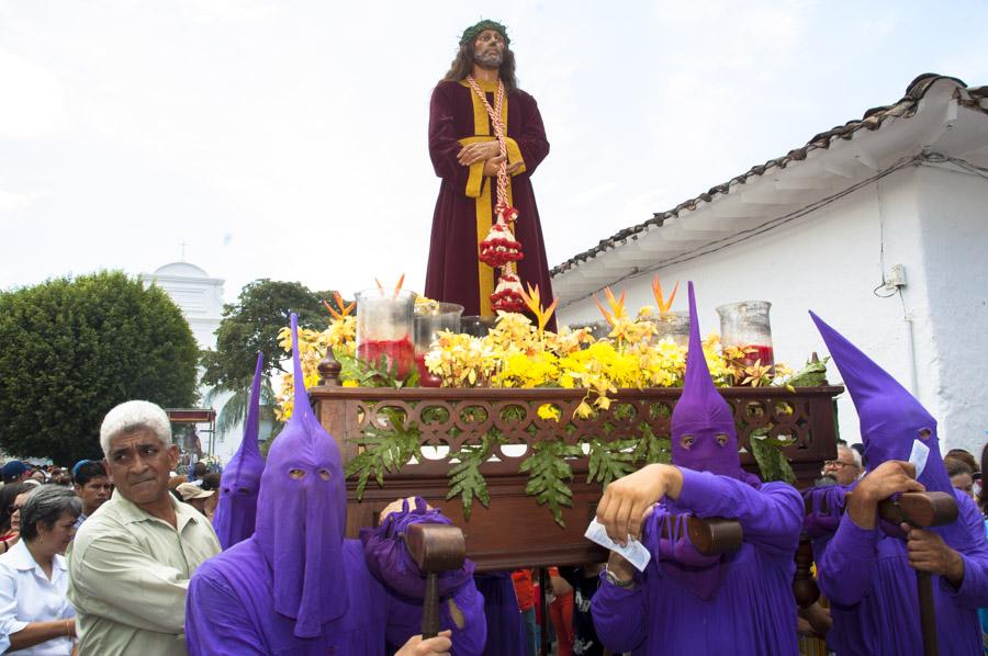 Personas con casulla llevando una imagen religiosa...