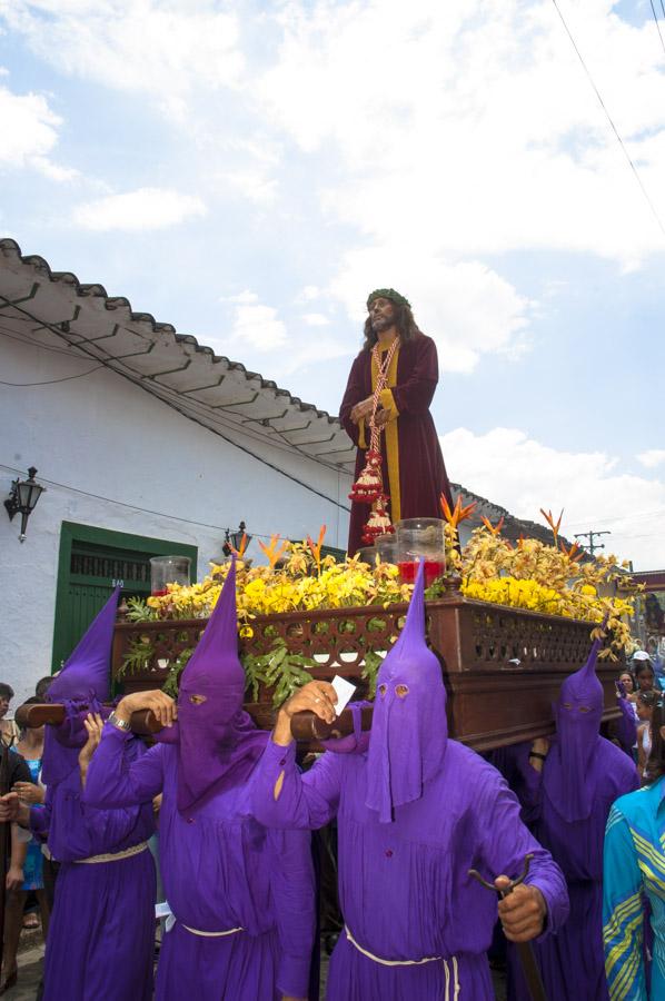 Personas con casulla llevando una imagen religiosa...