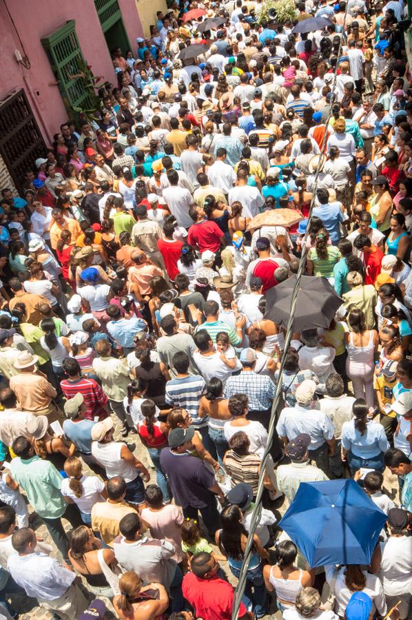 Aglomeracion de Personas por una calle en medio de...