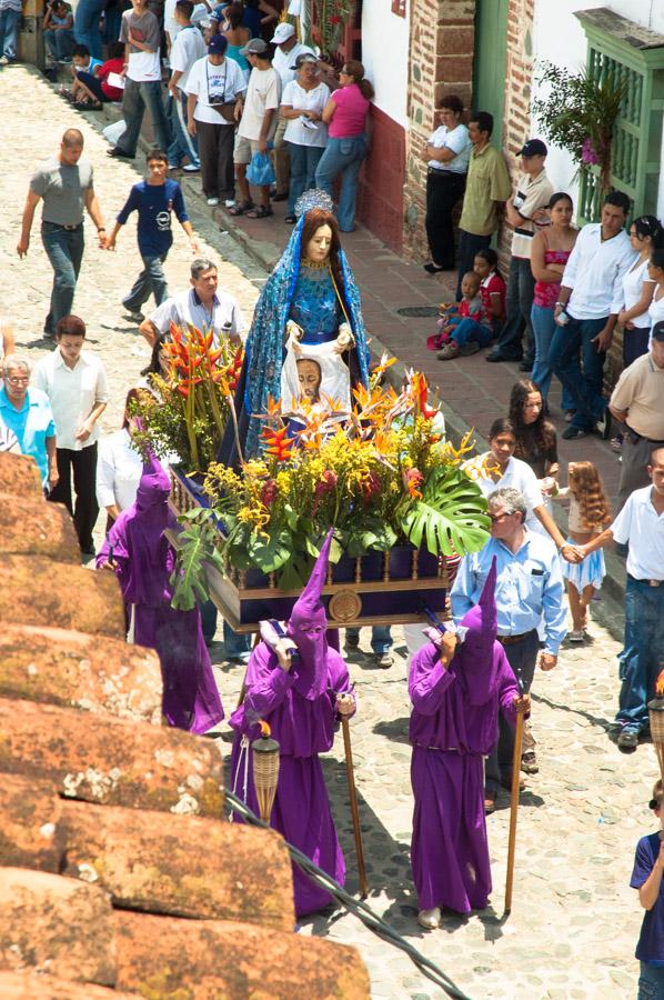 Personas con casulla llevando una imagen religiosa...