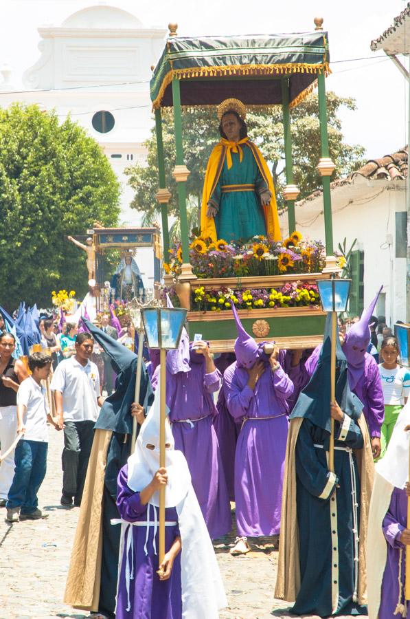 Personas con casulla llevando una imagen religiosa...