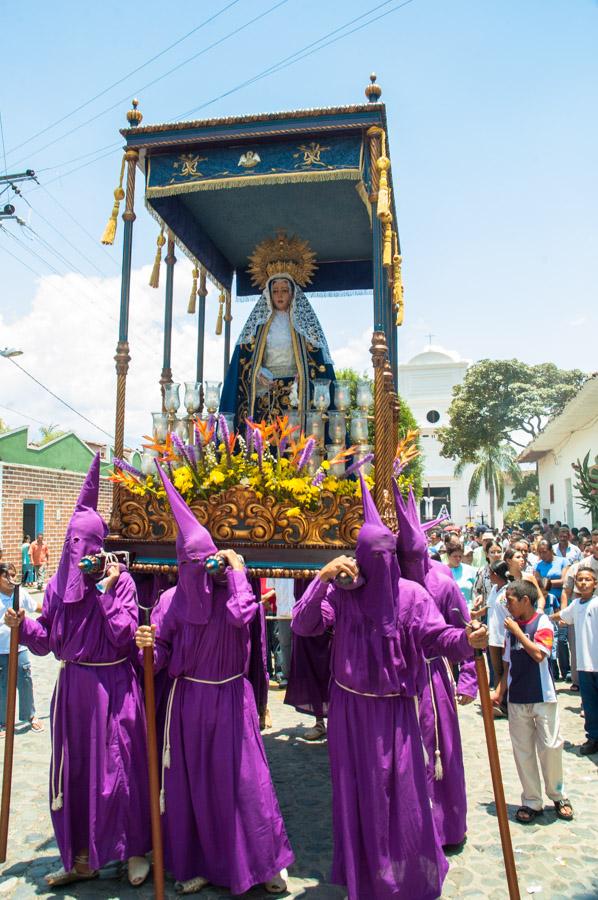 Personas con casulla llevando una imagen religiosa...