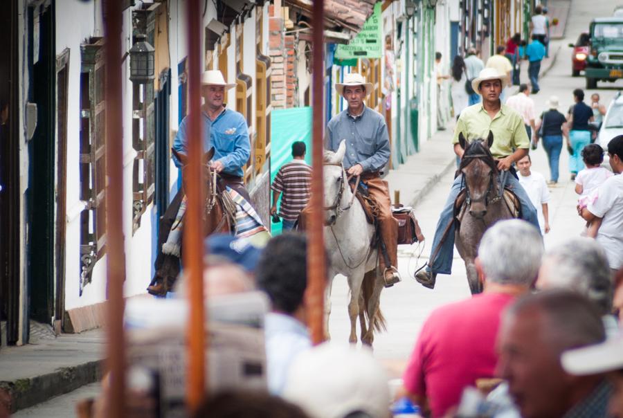 Personas montando a caballo en una calle de el Ret...